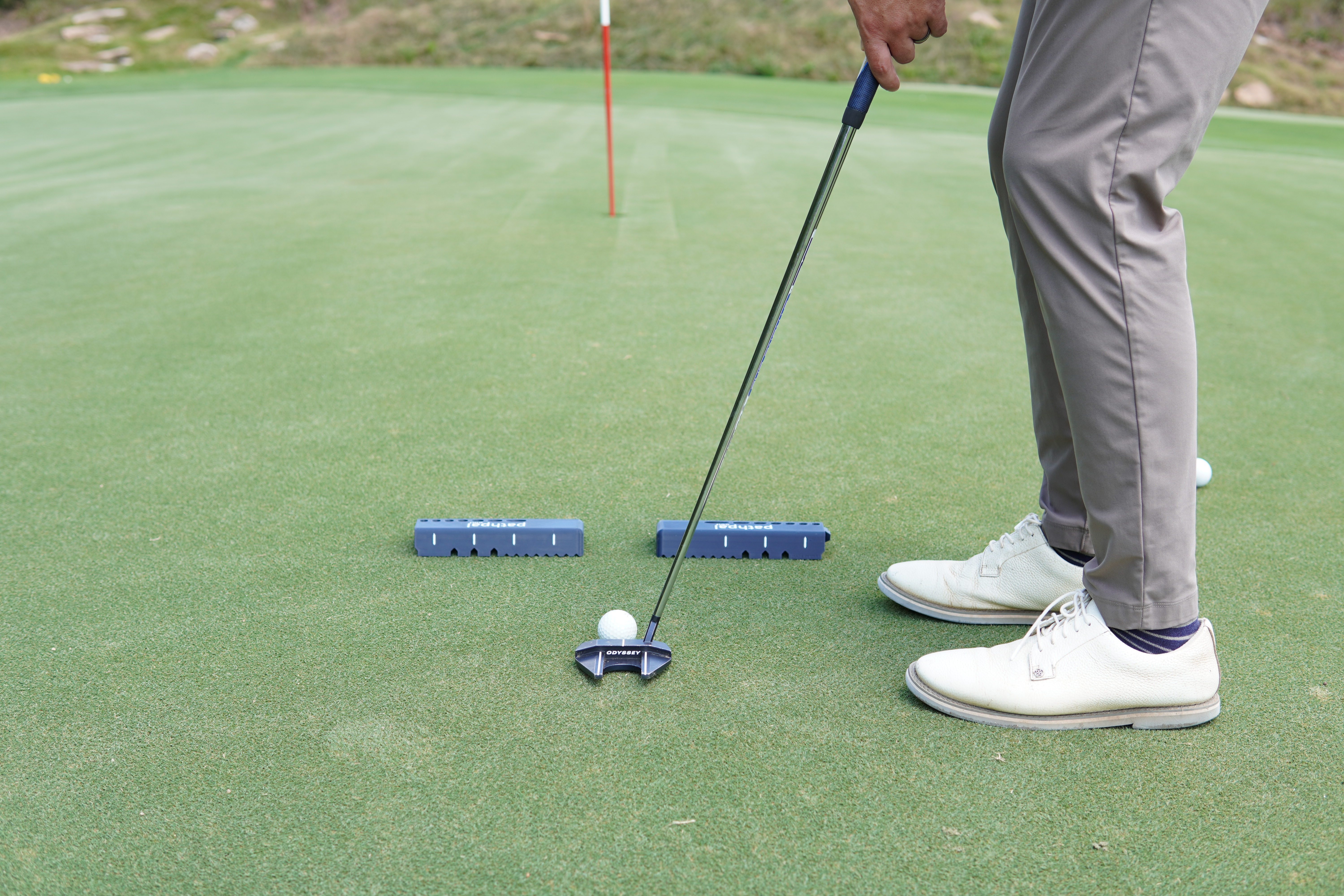 Golfer using pathpal for putting gate drill on practice green