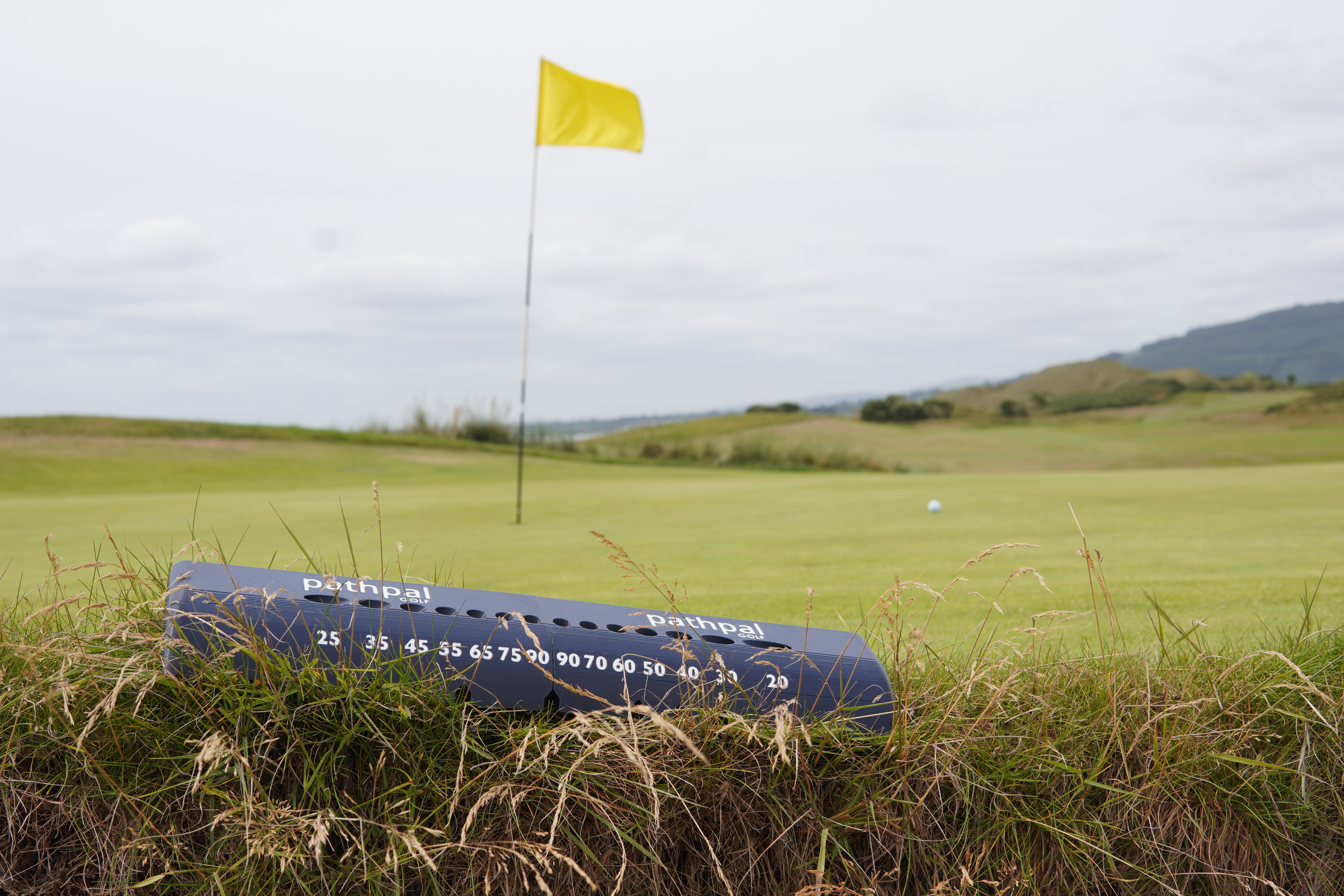 Pathpal training aid on grass near putting green with flag