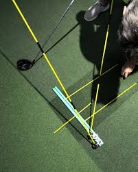 Overhead view of golfer positioning ball with Stryper SwingMate during setup