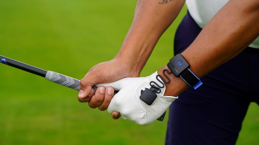 Hackmotion wrist sensor worn on golfer's wrist while gripping a golf club
