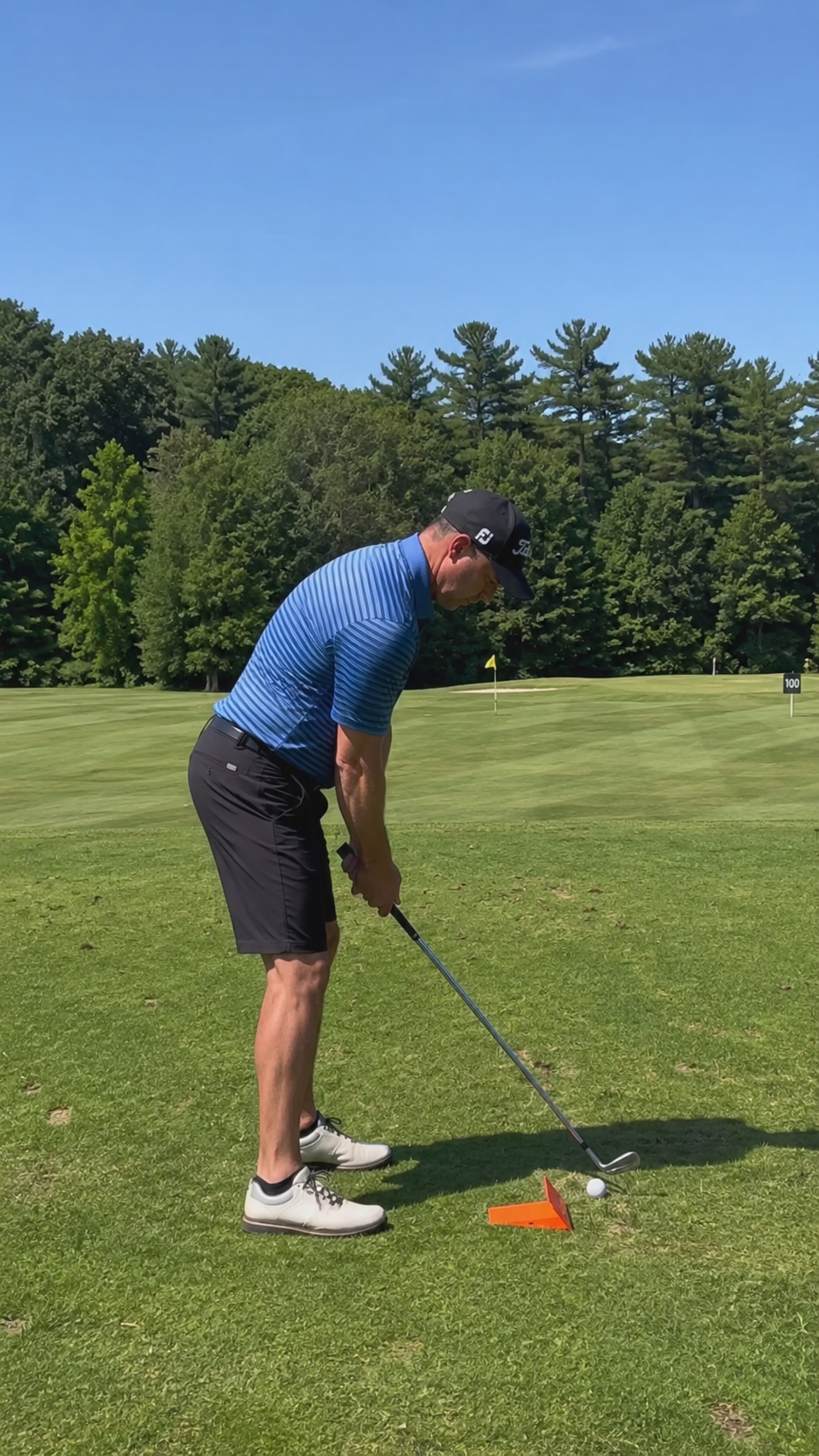 Golfer practicing on the course with the Strike Wedge training aid set up next to their ball