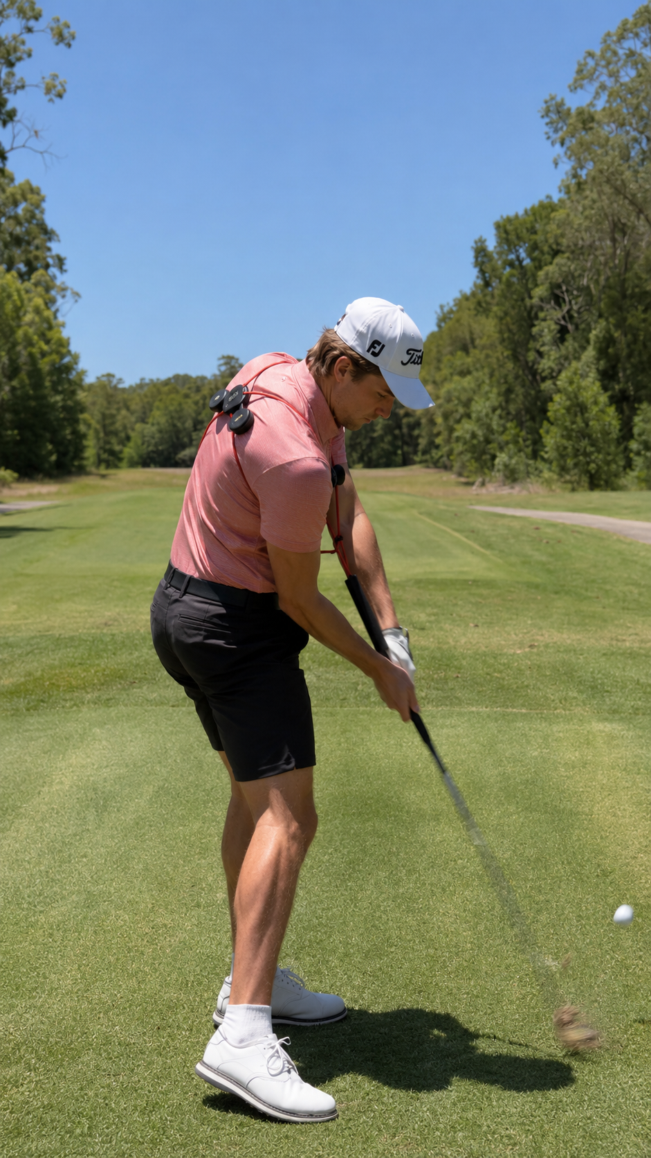 Golfer at the course swinging while wearing the GravityFit TPro posture trainer